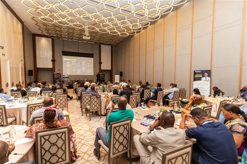 Salle de conférence pleine lors d’un workshop H&C, écran de projection au fond